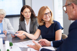 Business executives speaking and smiling to one another