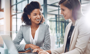 Two Business people smiling at one and other.