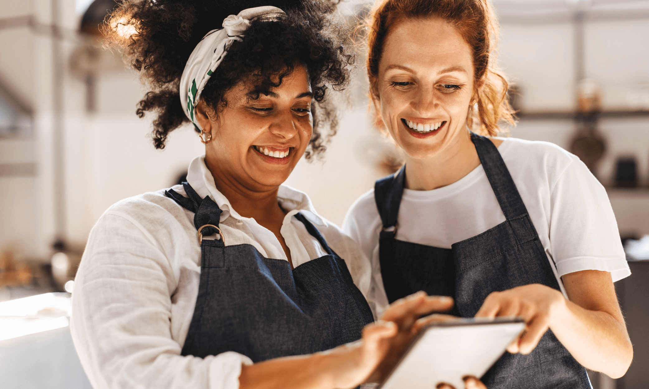Two people looking at a tablet in a restaurant.